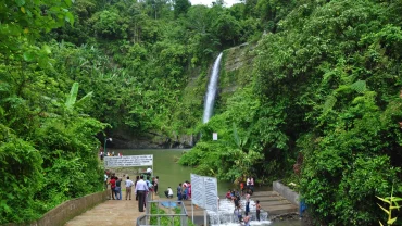 a group of people standing around a waterfall