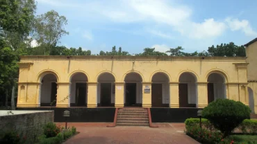 a yellow building with arches and steps leading to it