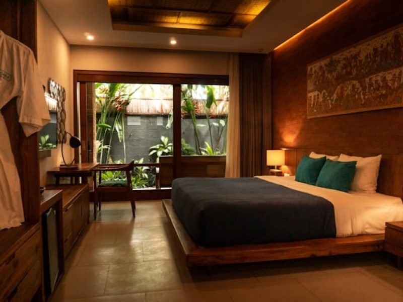 a bed room with a neatly made bed and a bathrobe