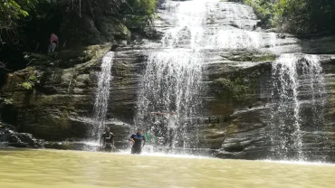 a group of people standing in front of a waterfall